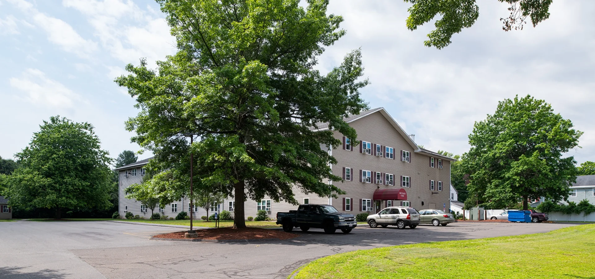 Orchard View building exterior, tree, and parking lot